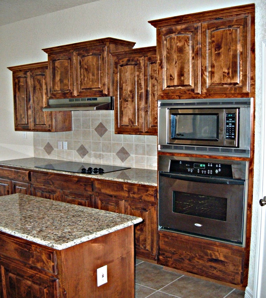 Example of a large mountain style u-shaped porcelain tile and beige floor eat-in kitchen design with a double-bowl sink, raised-panel cabinets, medium tone wood cabinets, granite countertops, beige backsplash, porcelain backsplash, stainless steel appliances, an island and multicolored countertops