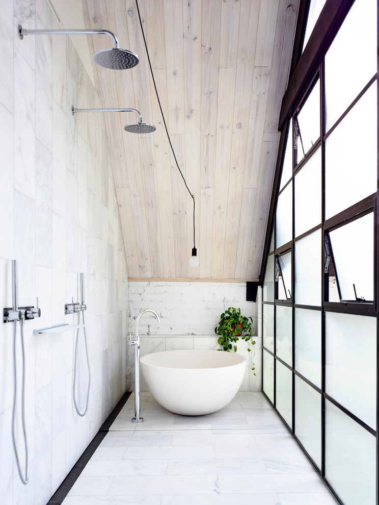 Foto på ett industriellt badrum, med ett fristående badkar, våtrum och med dusch som är öppen