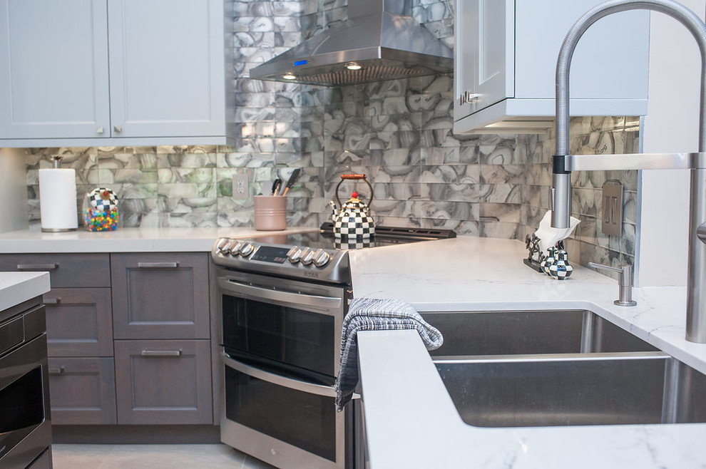 Example of a mid-sized transitional u-shaped porcelain tile and beige floor eat-in kitchen design in Miami with an undermount sink, shaker cabinets, gray cabinets, quartz countertops, gray backsplash, glass tile backsplash, stainless steel appliances, an island and white countertops