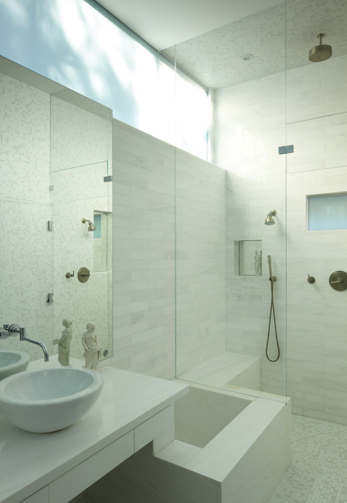 Inspiration for a mid-sized modern master bathroom in Los Angeles with a vessel sink, flat-panel cabinets, white cabinets, marble benchtops, a double shower, a one-piece toilet, white tile, stone tile, white walls and mosaic tile floors.