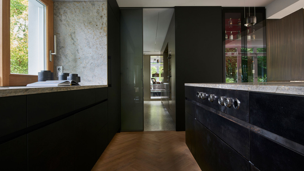 Foto di una cucina design con ante nere, parquet chiaro e top beige
