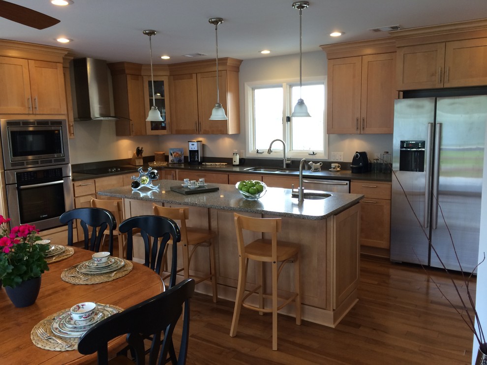 Mid-sized transitional u-shaped light wood floor open concept kitchen photo with an undermount sink, shaker cabinets, light wood cabinets, quartz countertops, stainless steel appliances and an island