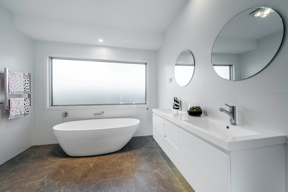 Photo of a mid-sized contemporary bathroom in Canberra - Queanbeyan with a freestanding tub, white tile, white walls, ceramic floors, an integrated sink, green floor and white benchtops.