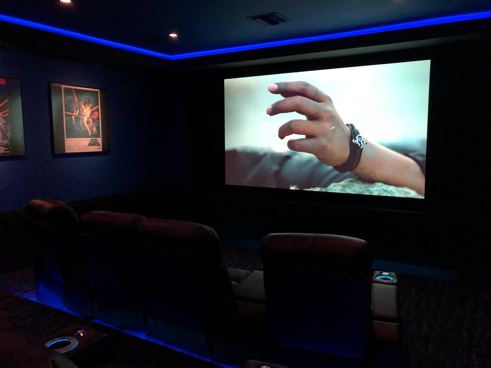 Mid-sized transitional enclosed home theatre in Orlando with blue walls, carpet, a projector screen and grey floor.