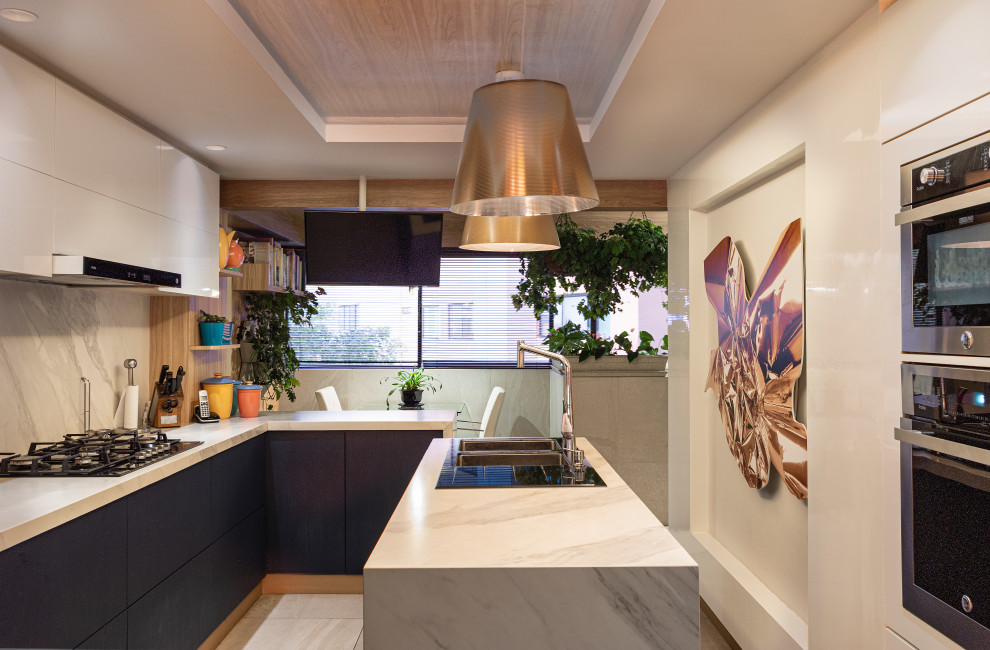 Photo of a medium sized modern kitchen in London with an integrated sink, white splashback, marble splashback, stainless steel appliances, porcelain flooring, a coffered ceiling and a feature wall.