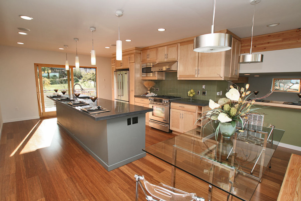 Inspiration for a large contemporary galley open plan kitchen in Seattle with an undermount sink, shaker cabinets, light wood cabinets, zinc benchtops, green splashback, ceramic splashback, stainless steel appliances, medium hardwood floors and with island.