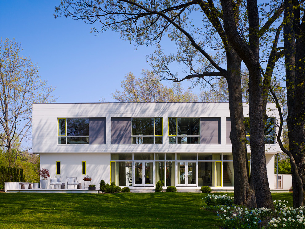Design ideas for a modern two-storey white exterior in Grand Rapids with a flat roof.