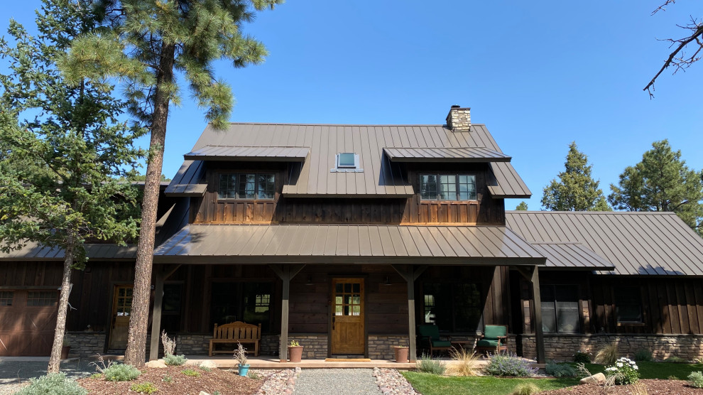 Foto de fachada de casa marrón y marrón campestre de dos plantas con revestimiento de madera, tejado de metal y panel y listón