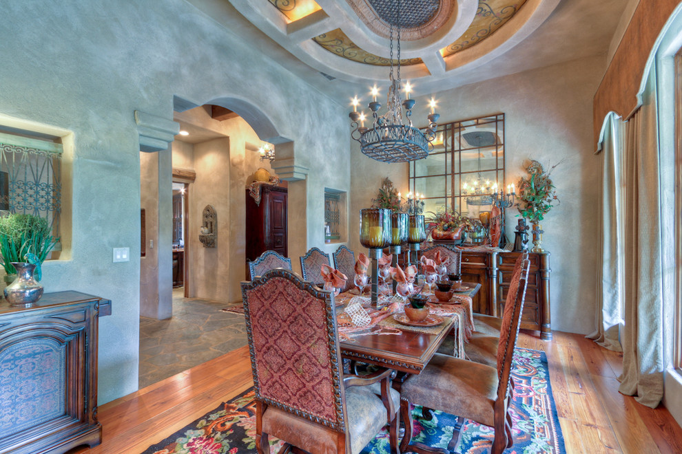 Photo of a mediterranean dining room in Austin with grey walls and medium hardwood floors.
