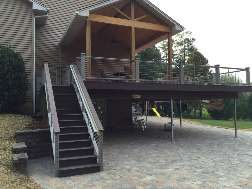 Large trendy backyard deck photo with a roof extension