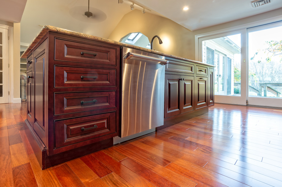 Large transitional single-wall light wood floor and brown floor eat-in kitchen photo in Philadelphia with an undermount sink, raised-panel cabinets, red cabinets, granite countertops, brown backsplash, porcelain backsplash, stainless steel appliances, an island and brown countertops