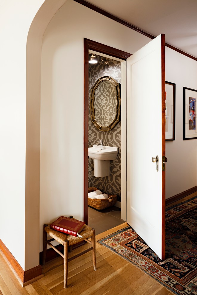 Design ideas for a small traditional powder room in Portland with a wall-mount sink, brown tile, a two-piece toilet, ceramic tile, multi-coloured walls and ceramic floors.