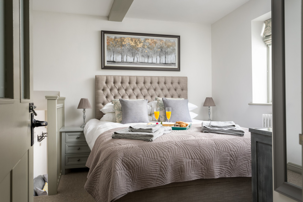 Mid-sized traditional loft-style bedroom in Gloucestershire with white walls, carpet and grey floor.