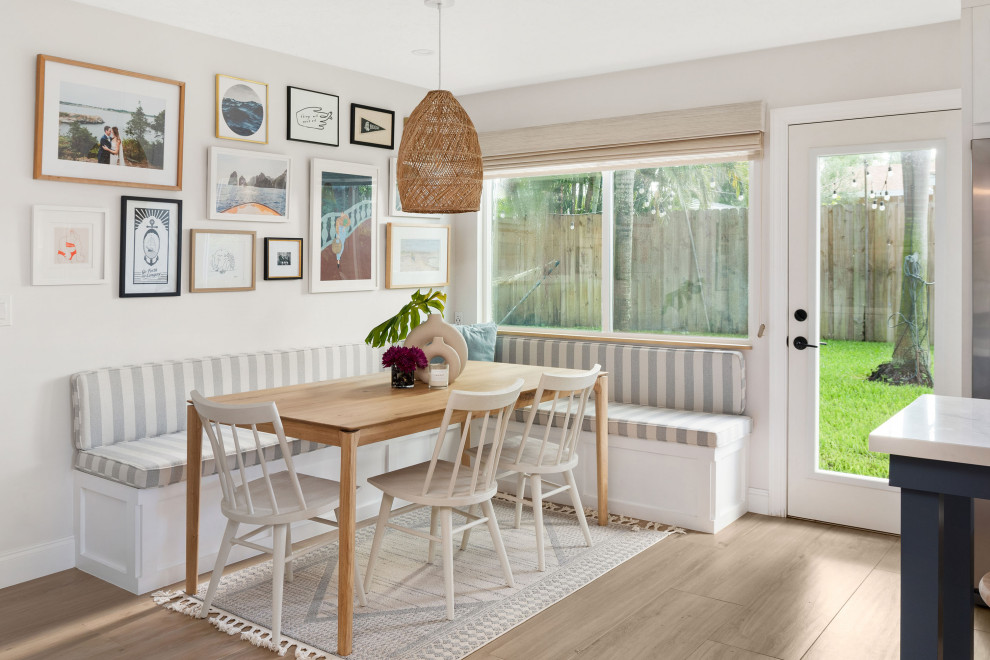 Immagine di una sala da pranzo aperta verso la cucina stile marinaro di medie dimensioni con pavimento in legno massello medio e pavimento marrone