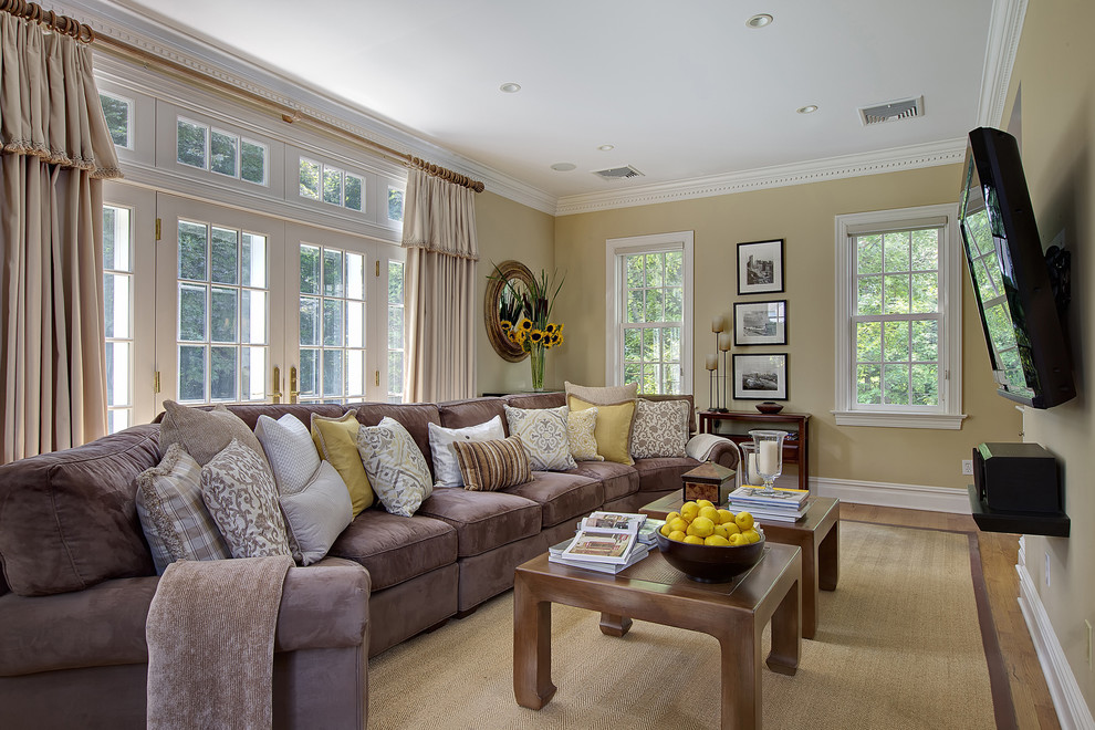 Photo of a traditional family room in New York with beige walls and a wall-mounted tv.