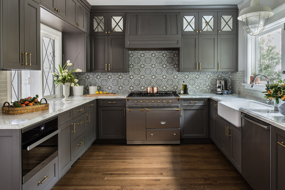 Transitional u-shaped kitchen in San Francisco with a farmhouse sink, shaker cabinets, grey cabinets, multi-coloured splashback, stainless steel appliances, medium hardwood floors, no island and multi-coloured benchtop.