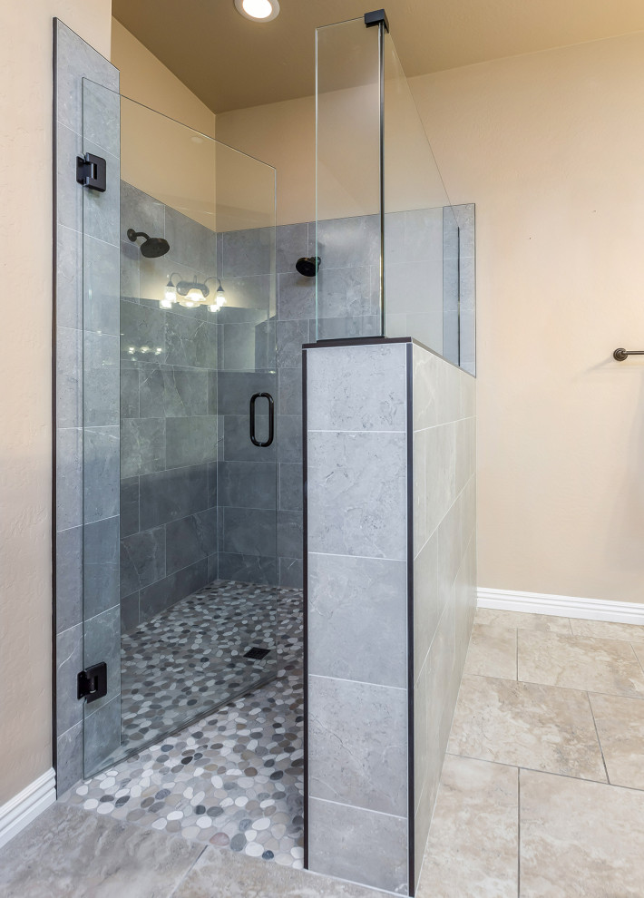 Photo of a large ensuite bathroom in Phoenix with an alcove shower, grey tiles, porcelain tiles, beige walls, pebble tile flooring, multi-coloured floors, a hinged door and a wall niche.