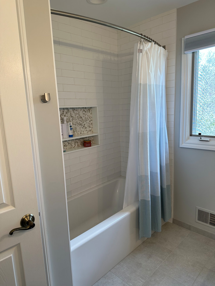 Medium sized classic family bathroom in Detroit with shaker cabinets, light wood cabinets, a built-in bath, a shower/bath combination, a two-piece toilet, white tiles, ceramic tiles, beige walls, porcelain flooring, a submerged sink, engineered stone worktops, beige floors, a shower curtain, white worktops, a wall niche, double sinks and a built in vanity unit.