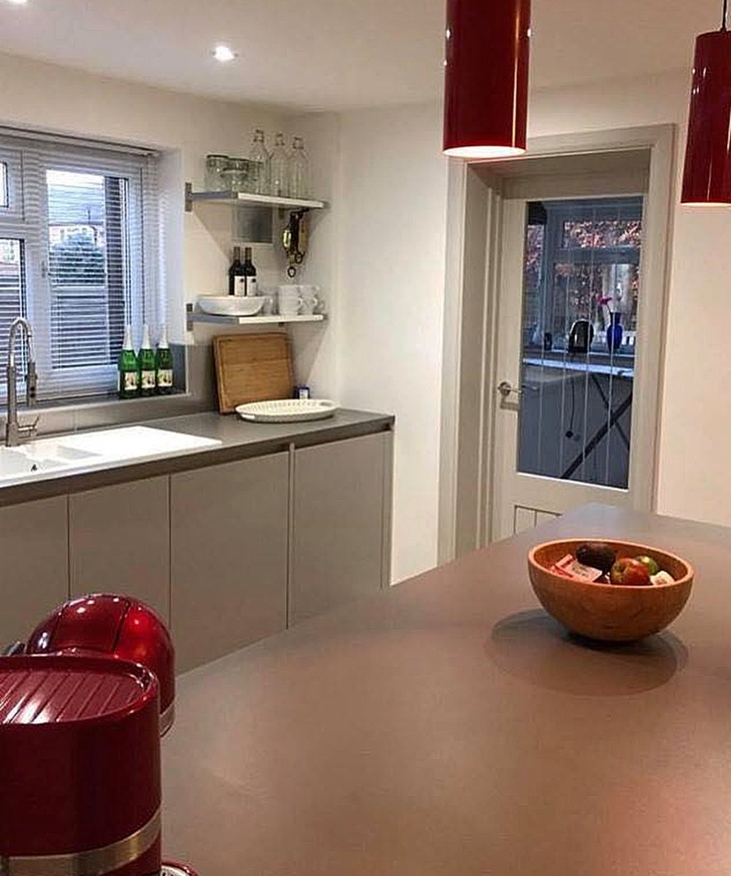 Design ideas for a mid-sized modern u-shaped eat-in kitchen in Hertfordshire with a drop-in sink, flat-panel cabinets, grey cabinets, laminate benchtops, grey splashback, vinyl floors, with island and grey benchtop.