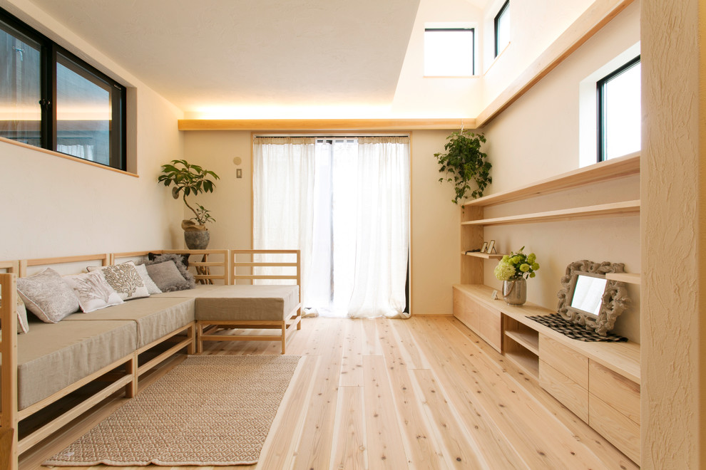 This is an example of an asian living room in Yokohama with white walls, light hardwood floors and brown floor.