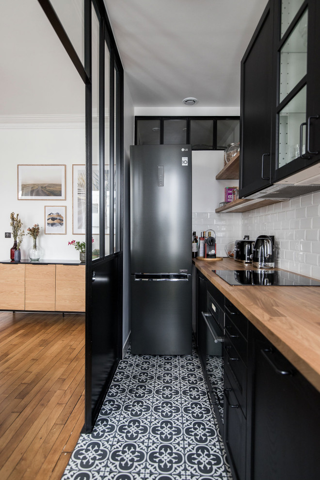 Inspiration for a small contemporary single-wall kitchen in Paris with black cabinets, laminate benchtops, white splashback, ceramic splashback, no island, shaker cabinets, black appliances, multi-coloured floor and brown benchtop.