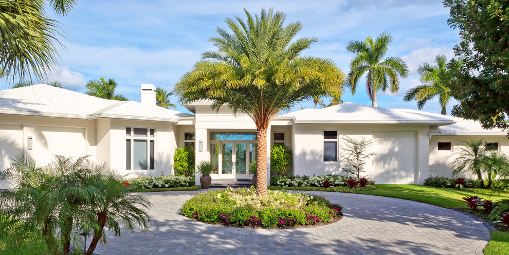 Tropical front yard full sun driveway in Miami with brick pavers and with flowerbed.