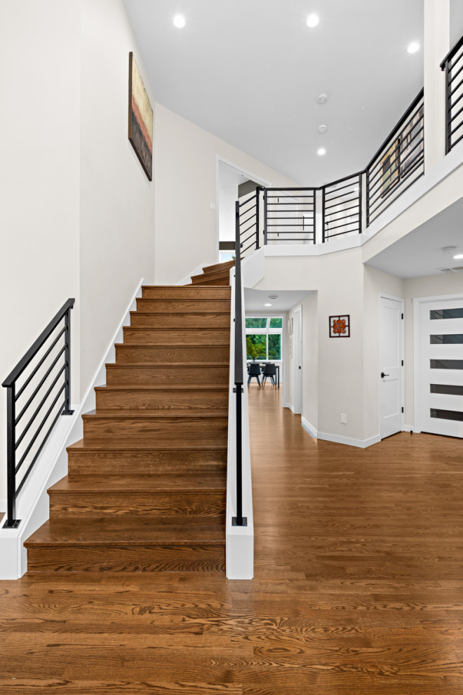 Photo of a large contemporary wood l-shaped metal railing staircase in Seattle with wood risers.