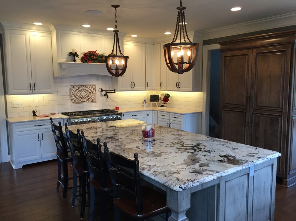 Example of a large transitional u-shaped dark wood floor eat-in kitchen design in Indianapolis with an undermount sink, raised-panel cabinets, white cabinets, granite countertops, white backsplash, subway tile backsplash, stainless steel appliances and an island
