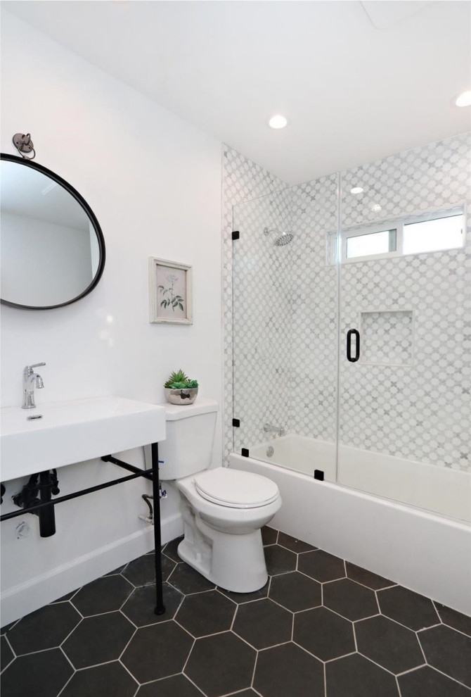 Стильный дизайн: ванная комната в средиземноморском стиле с черными фасадами, ванной в нише, душем над ванной, унитазом-моноблоком, белой плиткой, керамической плиткой, белыми стенами, полом из керамической плитки, консольной раковиной, столешницей из искусственного камня, черным полом, душем с распашными дверями, белой столешницей, нишей, тумбой под одну раковину и напольной тумбой - последний тренд