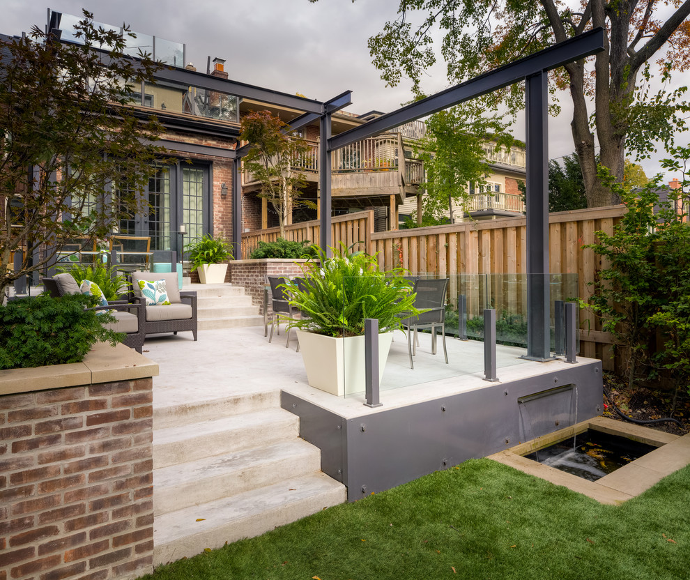 This is an example of a contemporary backyard patio in Toronto with a pergola.