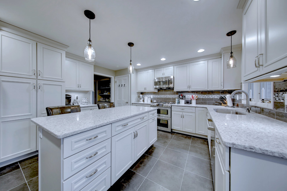 Large transitional u-shaped vinyl floor and gray floor kitchen photo with quartz countertops, gray backsplash, mosaic tile backsplash, an island, an undermount sink, beaded inset cabinets, white cabinets and stainless steel appliances