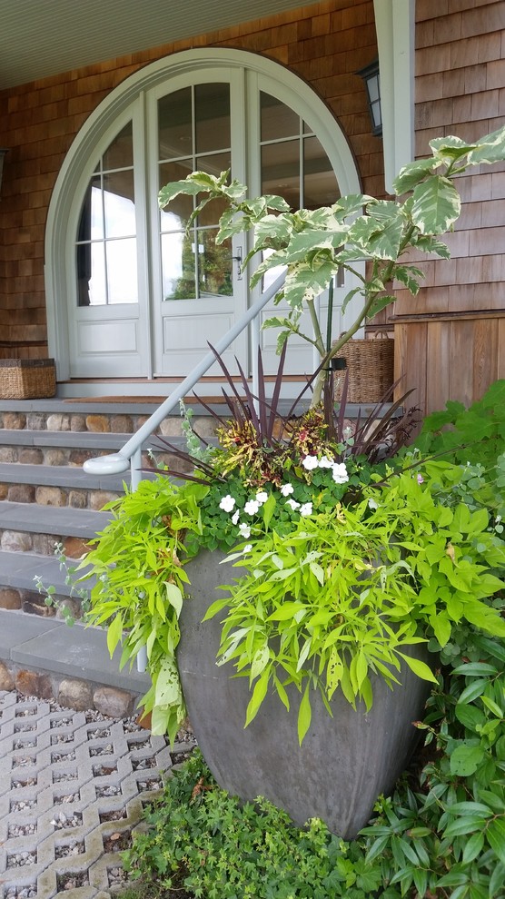 This is an example of a small cottage front porch design in Portland Maine with decking.