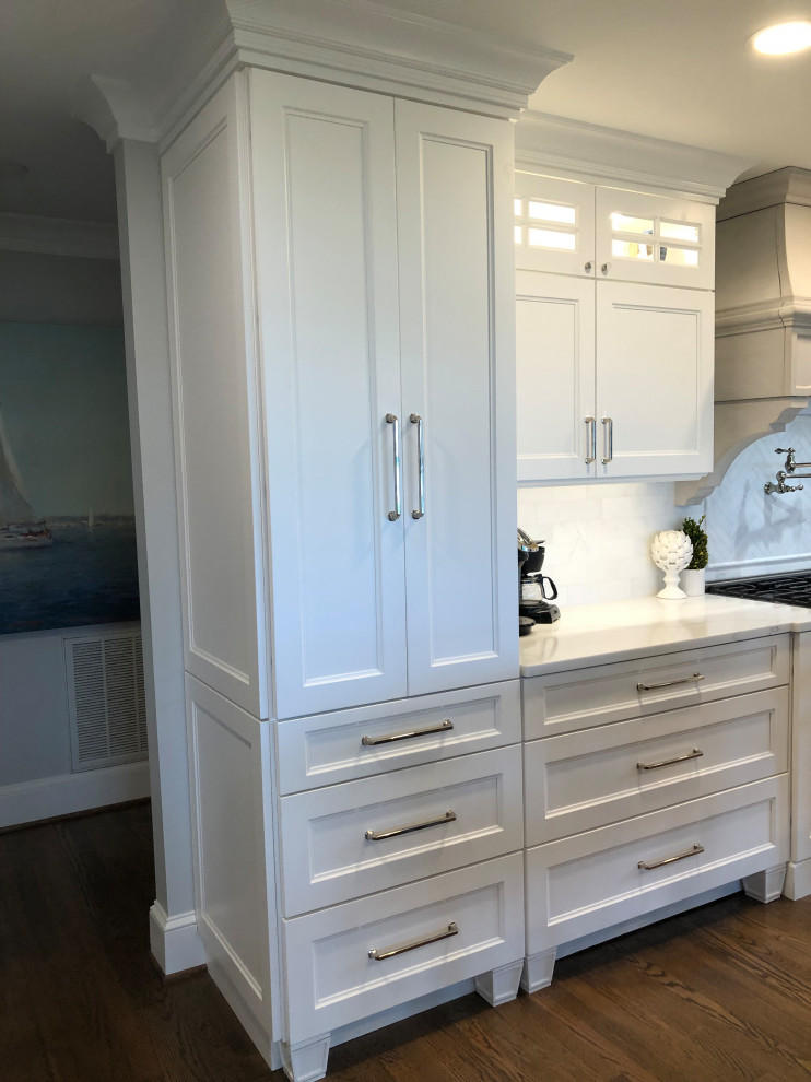 Inspiration for a large transitional l-shaped medium tone wood floor and brown floor eat-in kitchen remodel in Baltimore with a farmhouse sink, flat-panel cabinets, white cabinets, quartz countertops, white backsplash, subway tile backsplash, stainless steel appliances, an island and white countertops