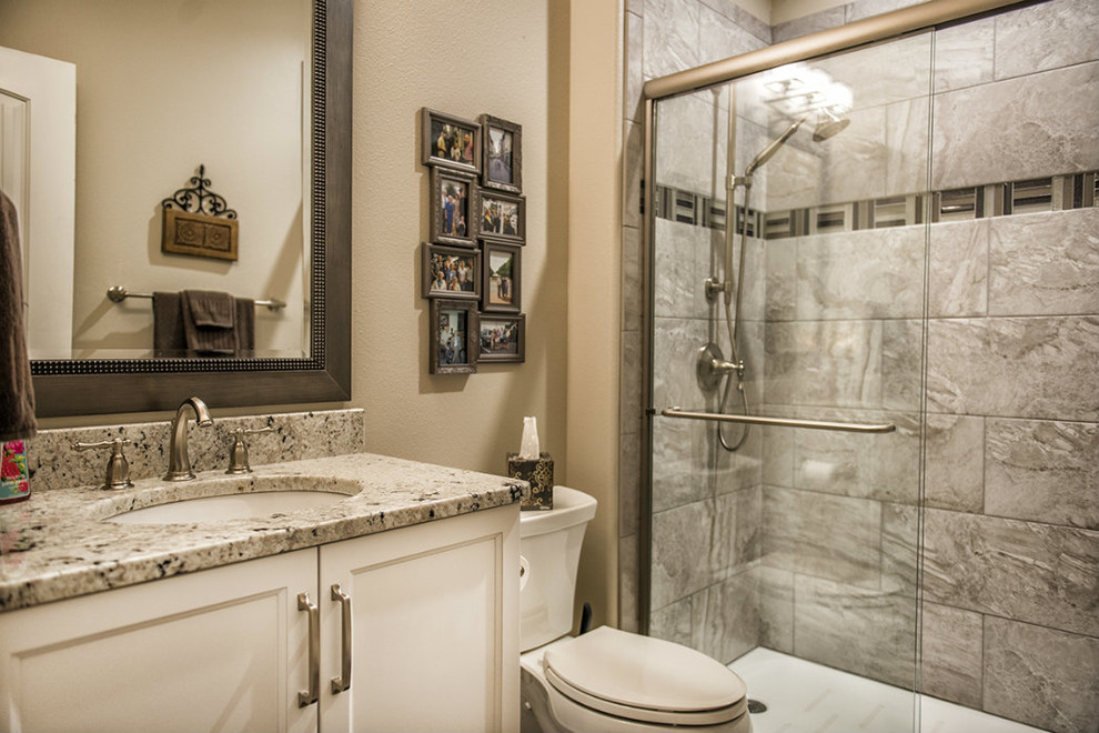 Example of a mid-sized transitional alcove bathtub design with recessed-panel cabinets, white cabinets, a two-piece toilet, beige walls, an undermount sink and granite countertops