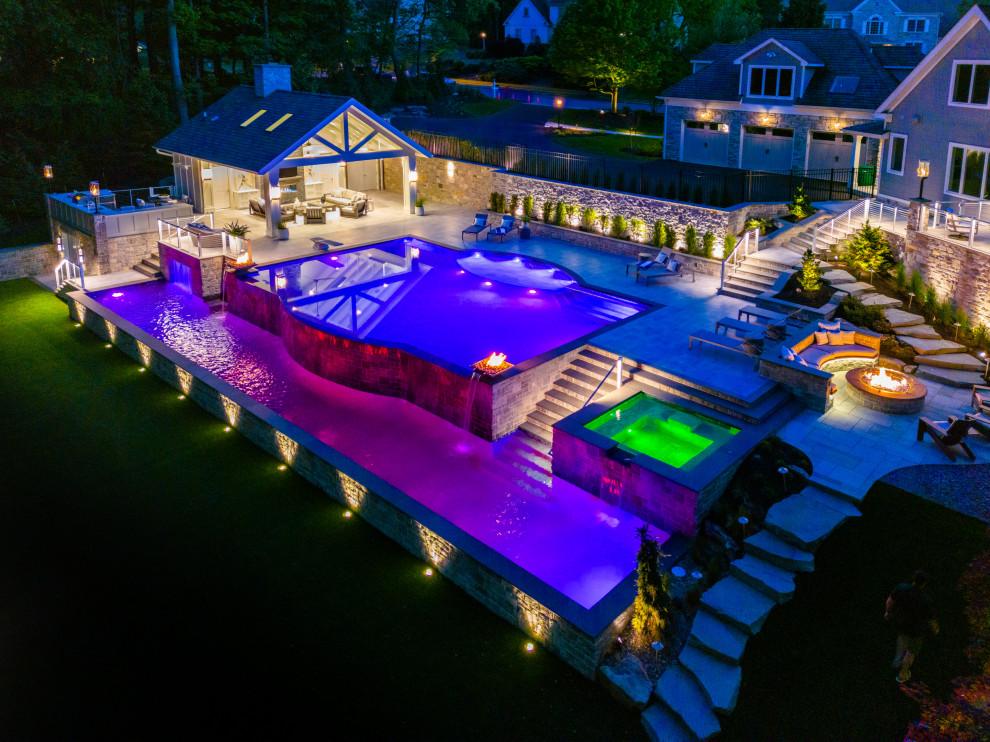 Huge transitional backyard tile and custom-shaped infinity pool house photo