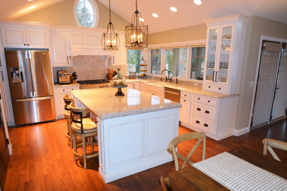Design ideas for a large country l-shaped eat-in kitchen in Indianapolis with a farmhouse sink, raised-panel cabinets, beige cabinets, granite benchtops, grey splashback, stone tile splashback, stainless steel appliances, dark hardwood floors and with island.
