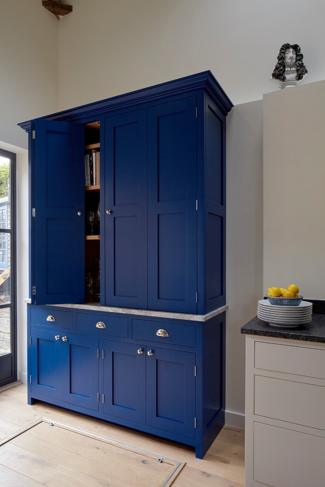 Inspiration for a large traditional open plan kitchen in London with a drop-in sink, shaker cabinets, blue cabinets, marble benchtops, white splashback, subway tile splashback, stainless steel appliances, light hardwood floors, multiple islands and brown floor.