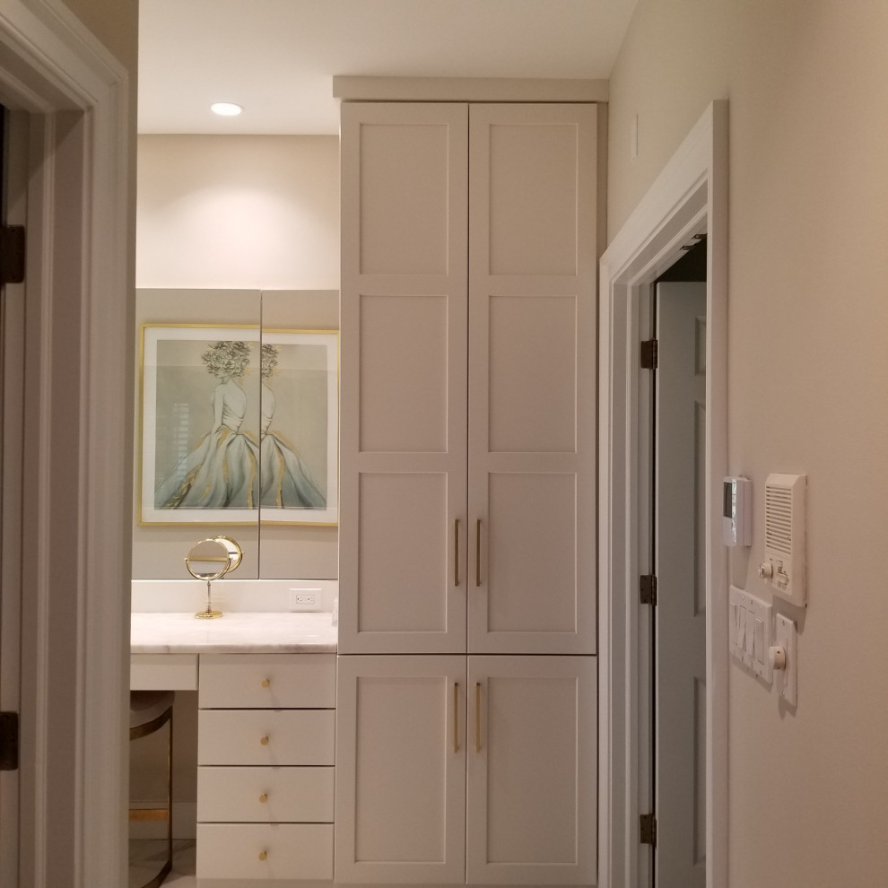 Modern inredning av ett stort vit vitt en-suite badrum, med släta luckor, vita skåp, flerfärgad kakel, marmorgolv, ett undermonterad handfat och vitt golv