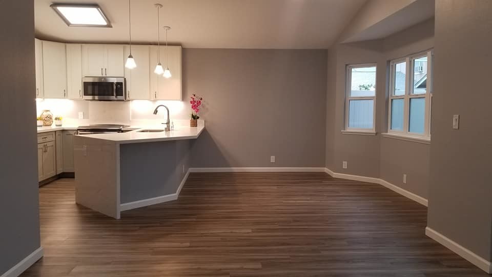 Mid-sized transitional u-shaped medium tone wood floor and brown floor eat-in kitchen photo in Hawaii with an undermount sink, shaker cabinets, white cabinets, quartz countertops, stainless steel appliances, a peninsula and gray countertops