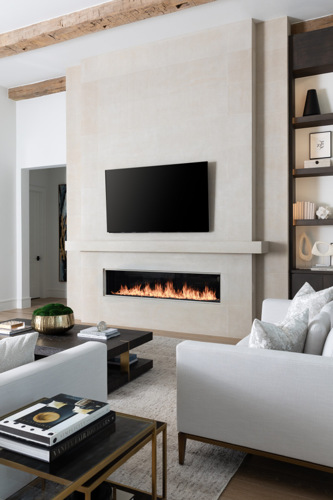 ダラスにある高級なコンテンポラリースタイルのおしゃれなリビング (石材の暖炉まわり、壁掛け型テレビ、表し梁) の写真