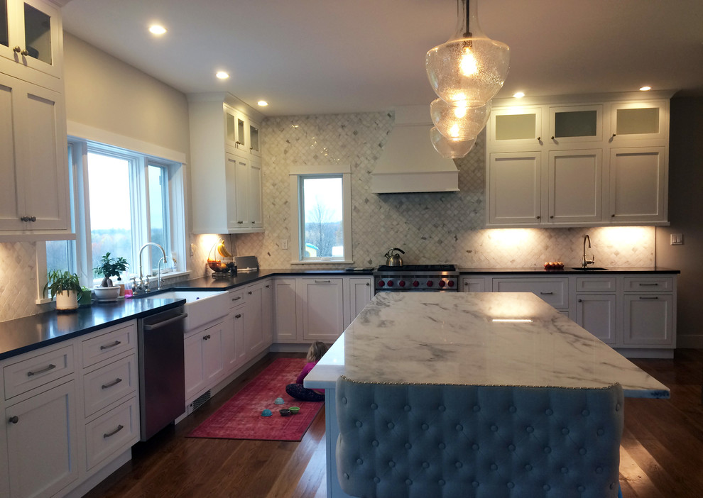 Inspiration for a large transitional u-shaped kitchen pantry remodel with a farmhouse sink, recessed-panel cabinets, white cabinets, quartzite countertops, stainless steel appliances, an island and black countertops