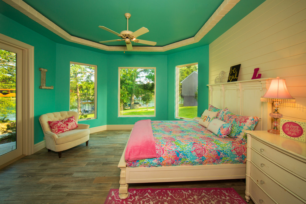 This is an example of a mid-sized mediterranean kids' room for girls in Austin with multi-coloured walls and light hardwood floors.