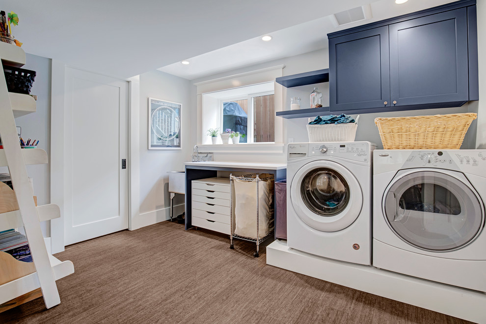 Inspiration for a mid-sized arts and crafts single-wall utility room in Seattle with an utility sink, flat-panel cabinets, blue cabinets, quartz benchtops, grey walls, a side-by-side washer and dryer, brown floor, white benchtop and bamboo floors.
