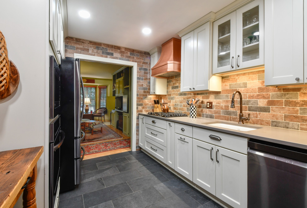 Design ideas for a mid-sized country u-shaped separate kitchen in DC Metro with a drop-in sink, recessed-panel cabinets, quartz benchtops, brick splashback, black appliances and no island.