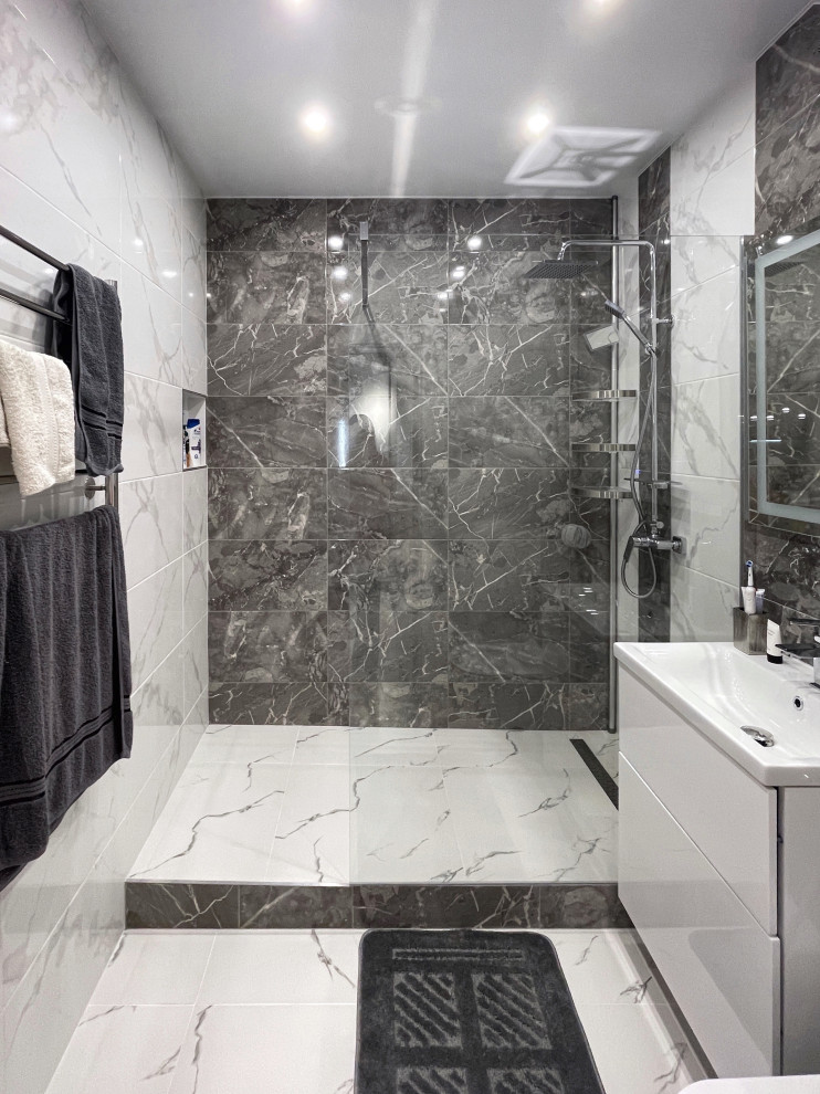 Inspiration för ett litet funkis badrum med dusch, med släta luckor, vita skåp, en öppen dusch, en vägghängd toalettstol, grå kakel, keramikplattor, grå väggar, klinkergolv i porslin, ett nedsänkt handfat, vitt golv och med dusch som är öppen