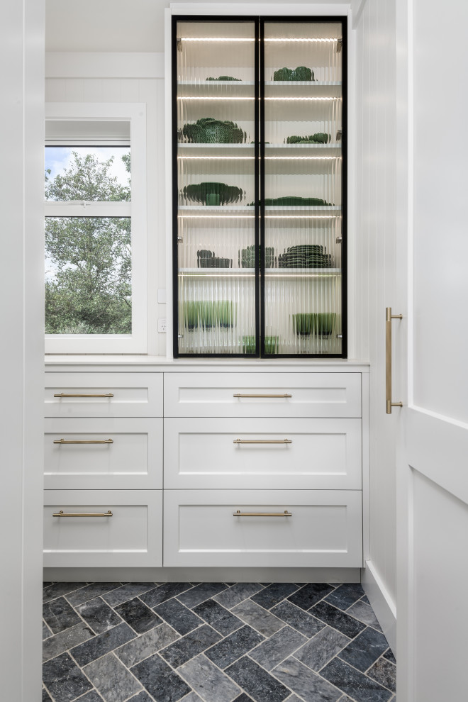 Design ideas for a mid-sized traditional l-shaped kitchen pantry in Christchurch with an undermount sink, shaker cabinets, white cabinets, white splashback, panelled appliances, slate floors, grey floor and white benchtop.