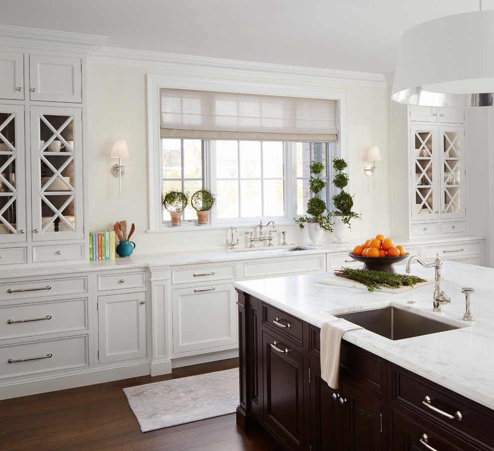 Design ideas for a large traditional u-shaped separate kitchen in Chicago with an undermount sink, white cabinets, with island, stainless steel appliances, recessed-panel cabinets, marble benchtops, white splashback, subway tile splashback and medium hardwood floors.