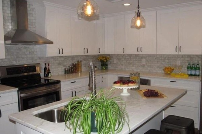 Transitional l-shaped dark wood floor eat-in kitchen photo in Boston with a double-bowl sink, shaker cabinets, white cabinets, marble countertops, gray backsplash, brick backsplash, stainless steel appliances and an island