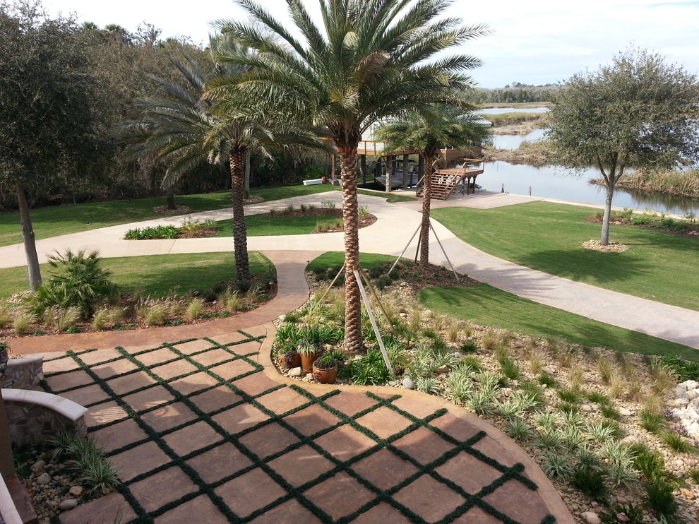 Mid-sized mediterranean backyard full sun garden in Orlando with a water feature and concrete pavers for summer.