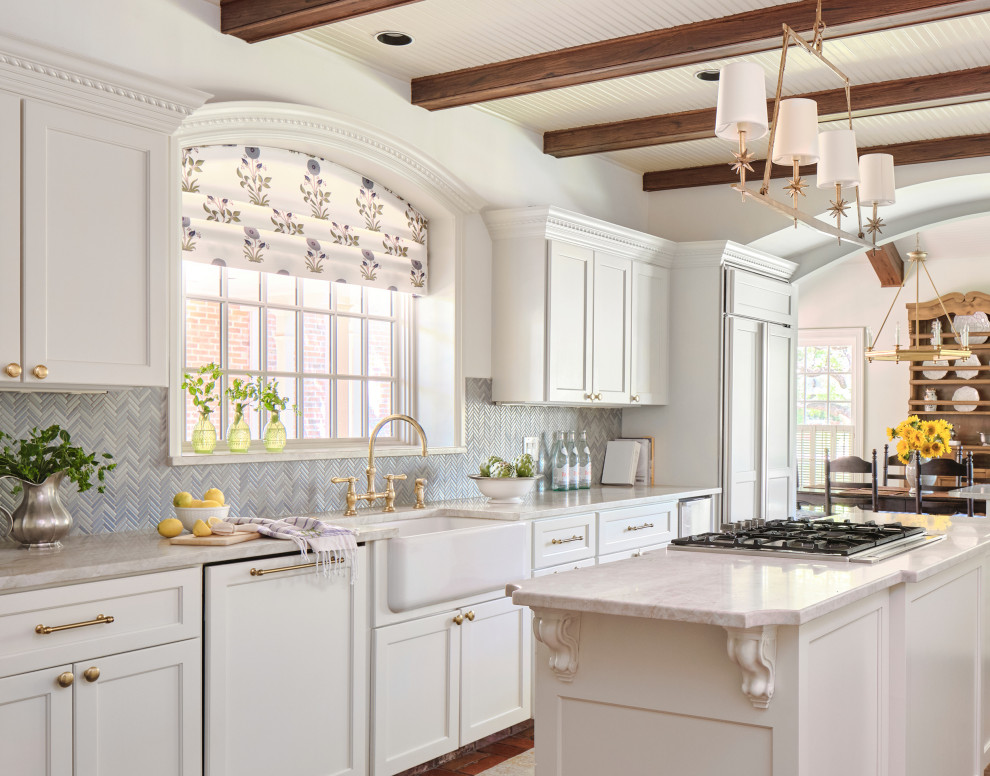 Eat-in kitchen - traditional l-shaped terra-cotta tile and exposed beam eat-in kitchen idea in Austin with a farmhouse sink, recessed-panel cabinets, white cabinets, marble countertops, blue backsplash, glass tile backsplash, paneled appliances, an island and white countertops
